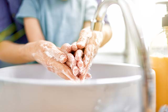 persona lavando las manos a un niño 