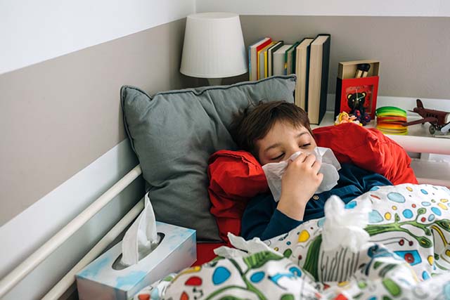 niño resfriado en la cama